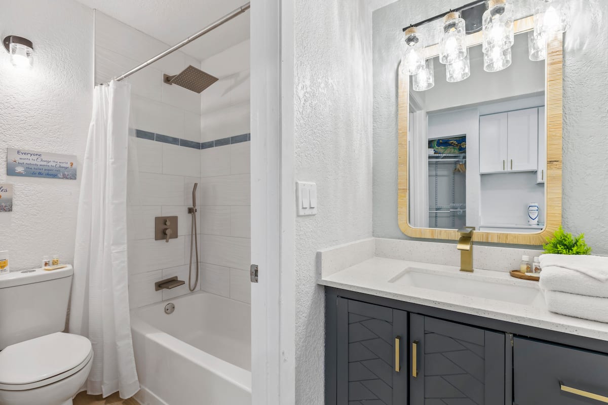 Modern bathroom with tub, vanity, mirror