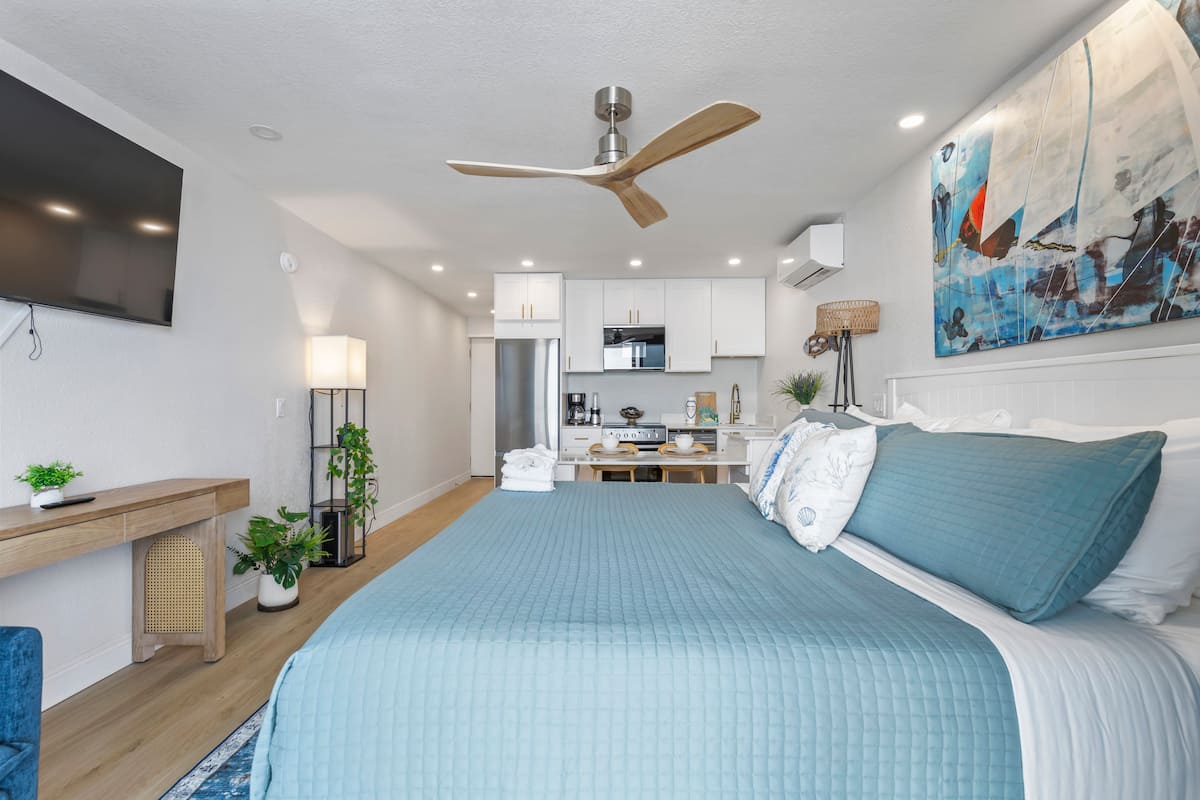 Modern studio bedroom with kitchenette and teal bedding