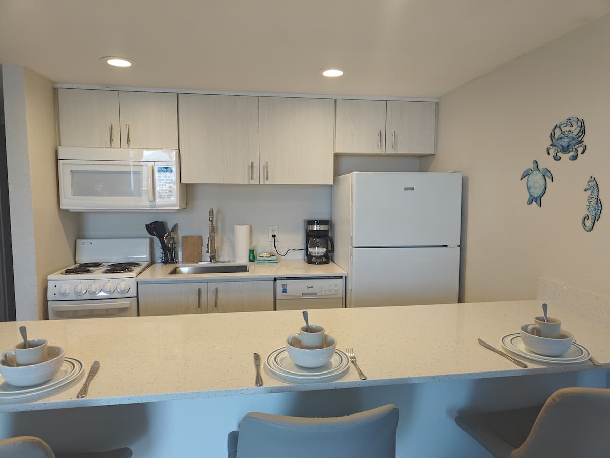 Modern kitchenette with breakfast bar set for three