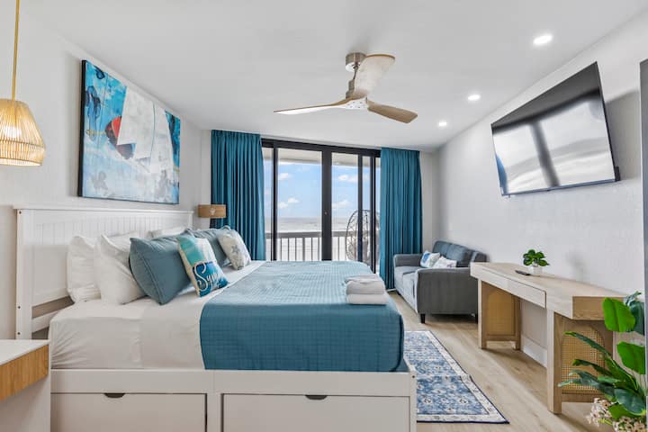 Bright beachfront bedroom with teal accents and balcony