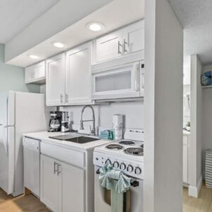 Compact white kitchenette with stove and refrigerator