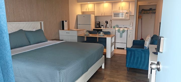 Studio apartment with blue bedding and kitchenette