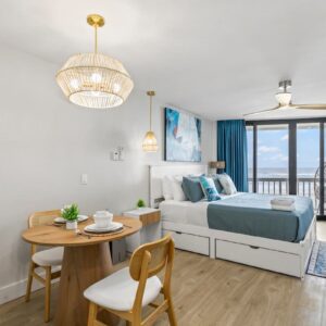 Ocean-view studio with blue bedding and balcony