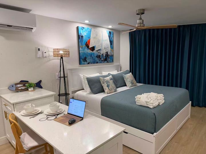 Modern bedroom with blue bedding and sailboat artwork