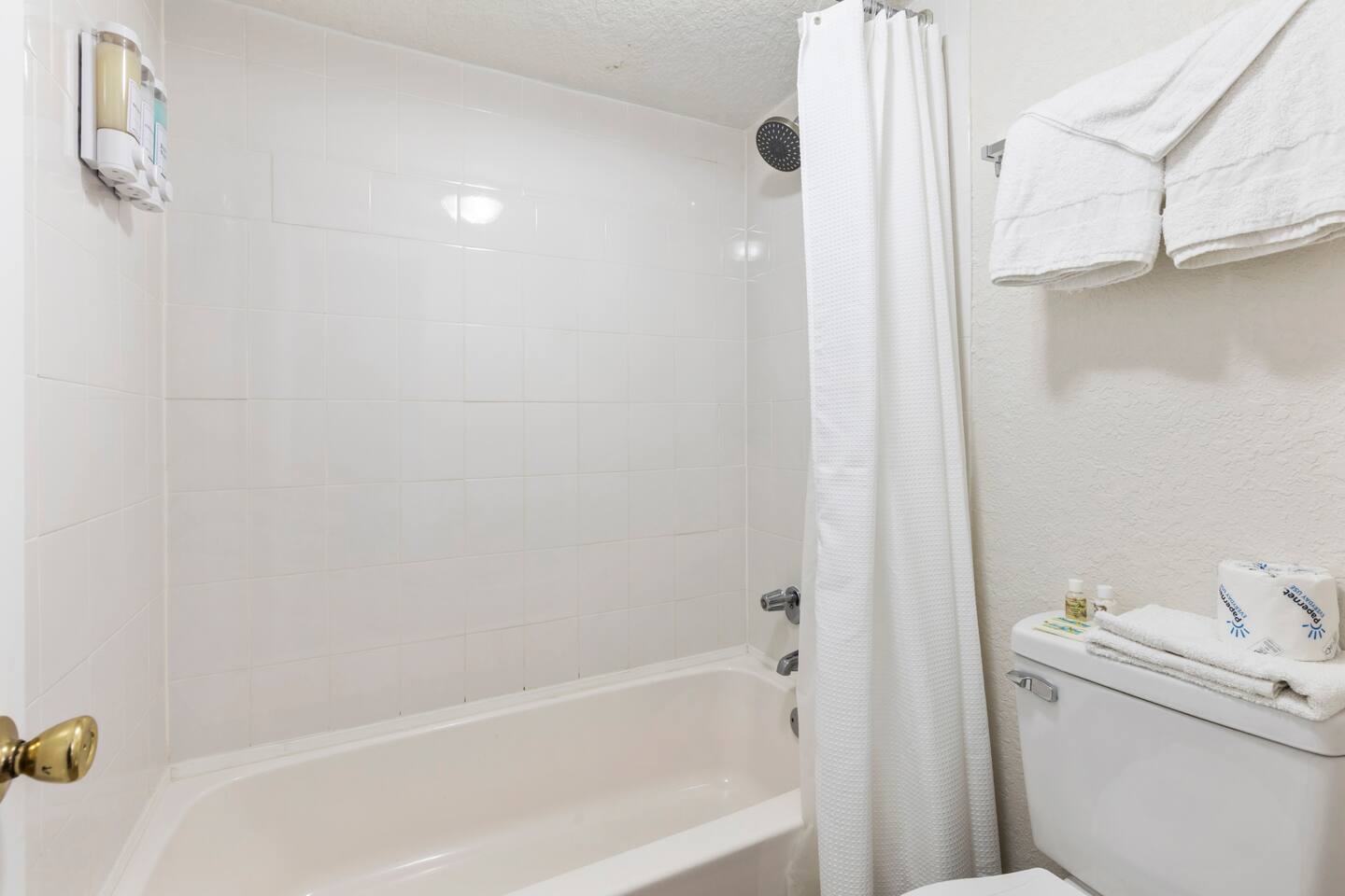 Clean white bathroom with bathtub and toilet