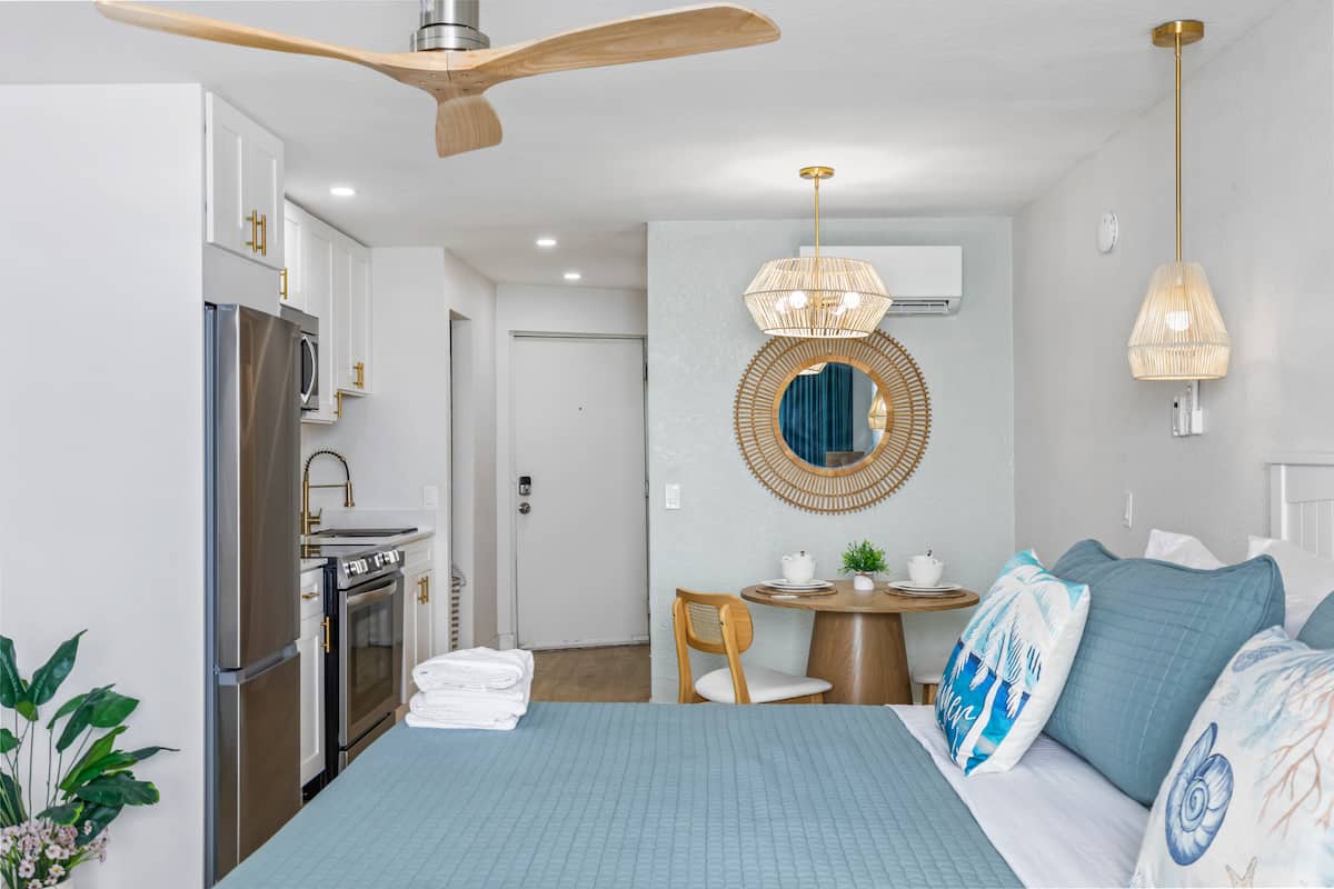 Modern studio with kitchenette and blue bedding