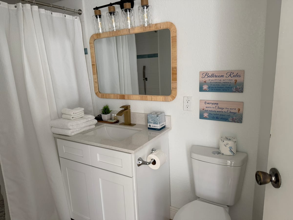 Modern white bathroom vanity with mirror and toilet