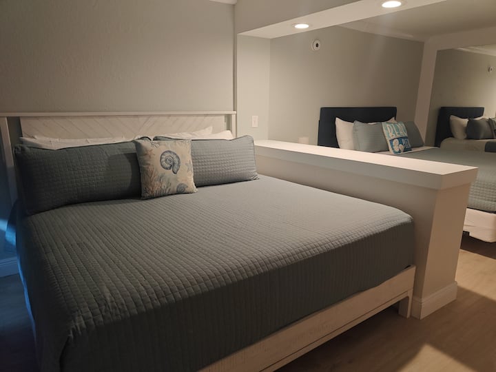 Modern bedroom with gray quilted bed and mirror