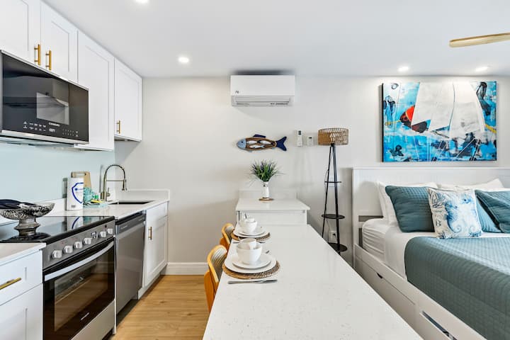 Modern studio kitchen and bedroom with sailboat artwork