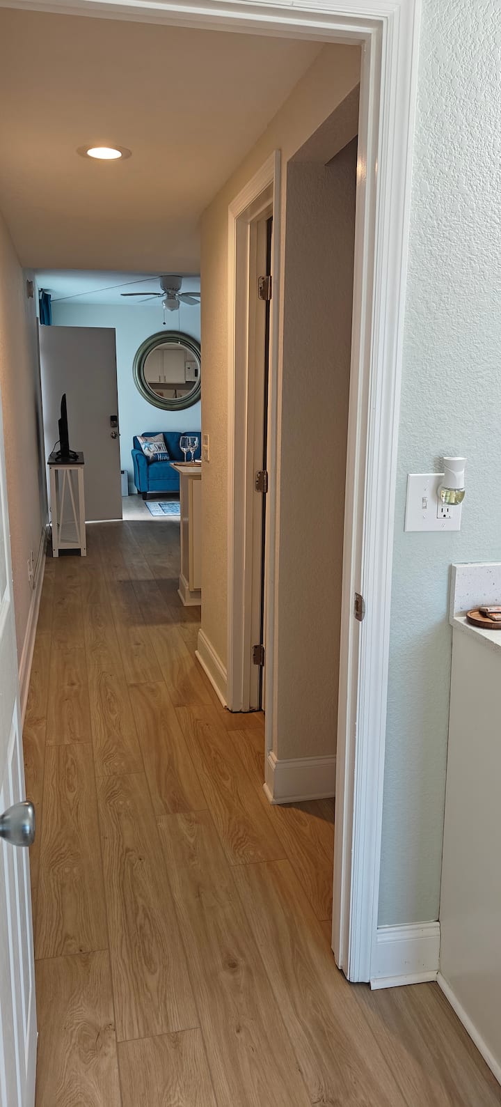 Hallway leading to living room with blue couch