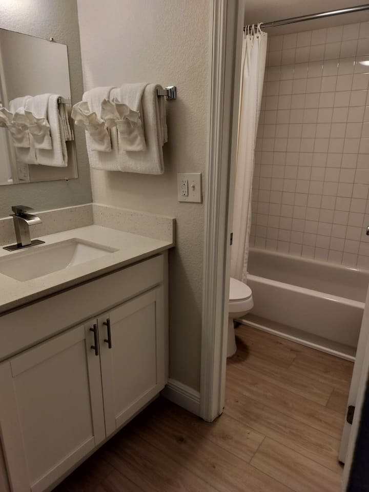 White bathroom vanity with sink and tub