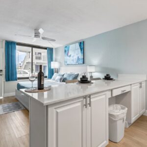 Bright studio apartment with white island, blue accents
