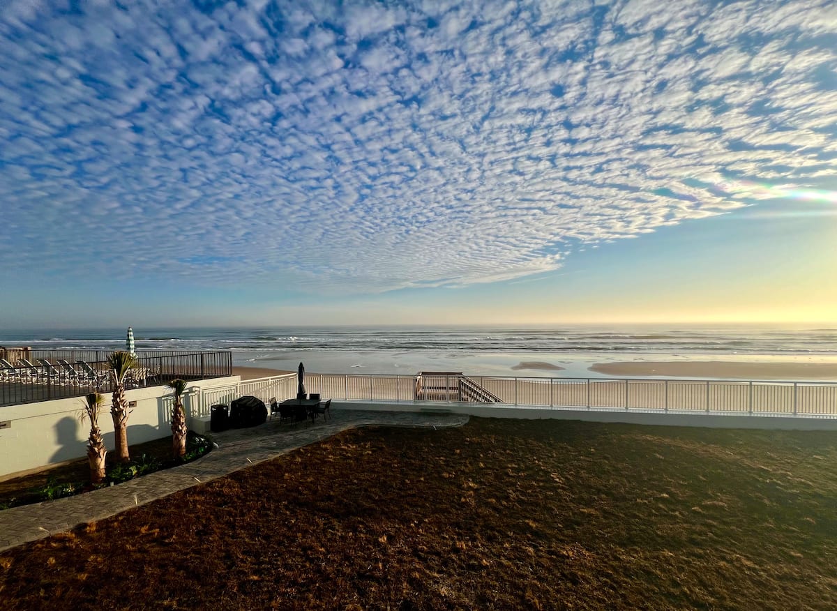 Oceanfront backyard with dramatic cloud-filled sky
