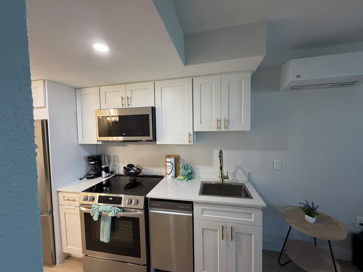 Modern kitchen with white cabinets, stainless appliances