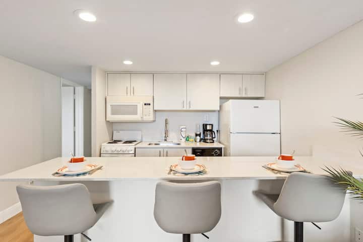Minimalist white kitchenette and trio of barstools