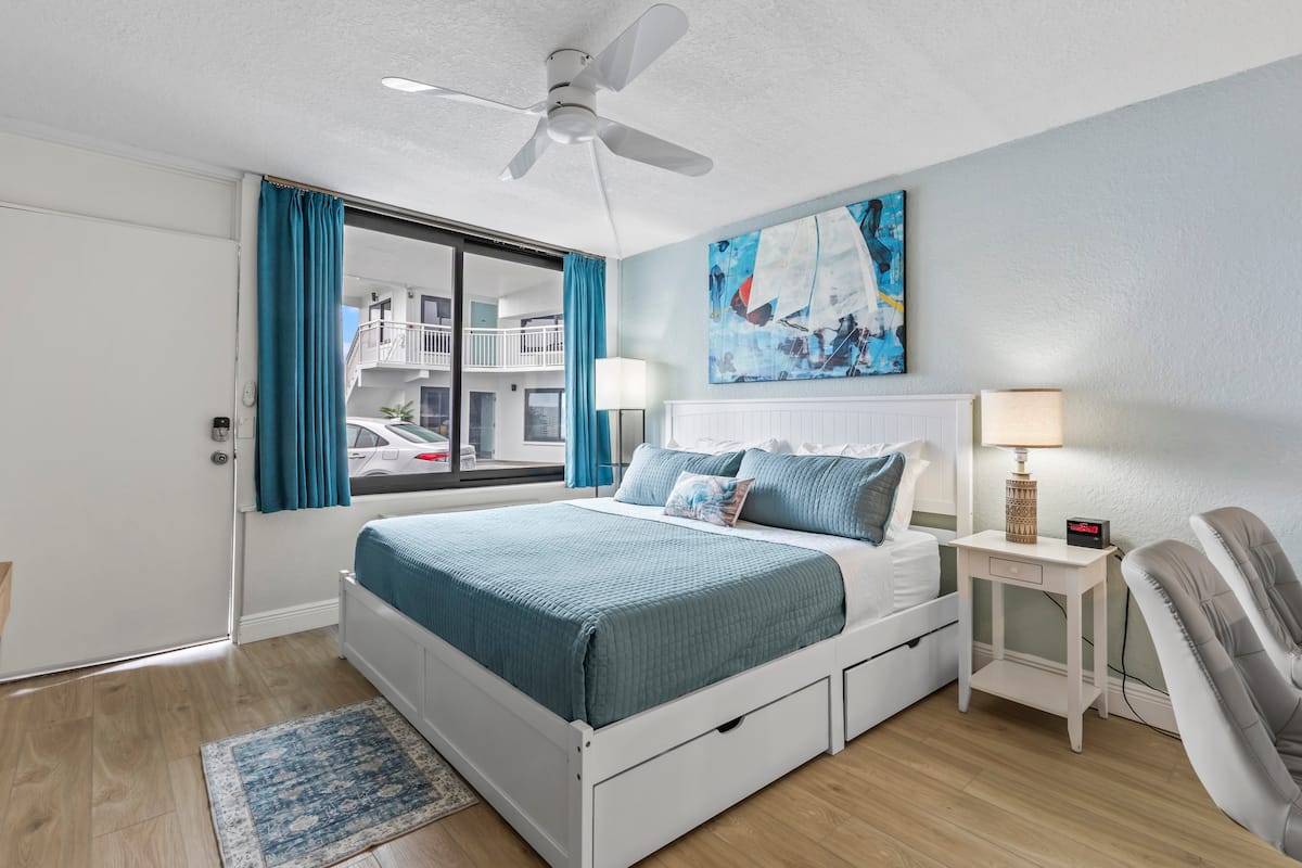 Bright coastal bedroom with white storage bed