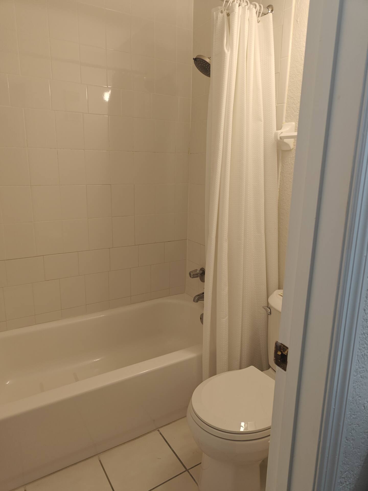 Small white bathroom with tub and toilet