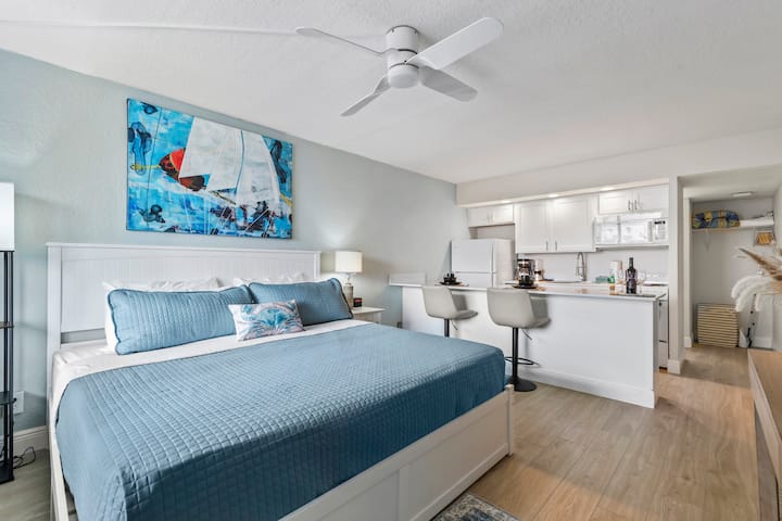 Modern studio with blue bed and kitchenette