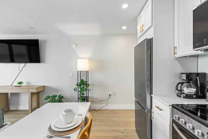 Bright modern kitchen island with stainless refrigerator