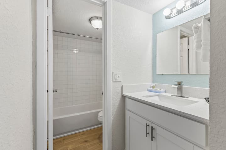 Bright bathroom with sink and tiled tub