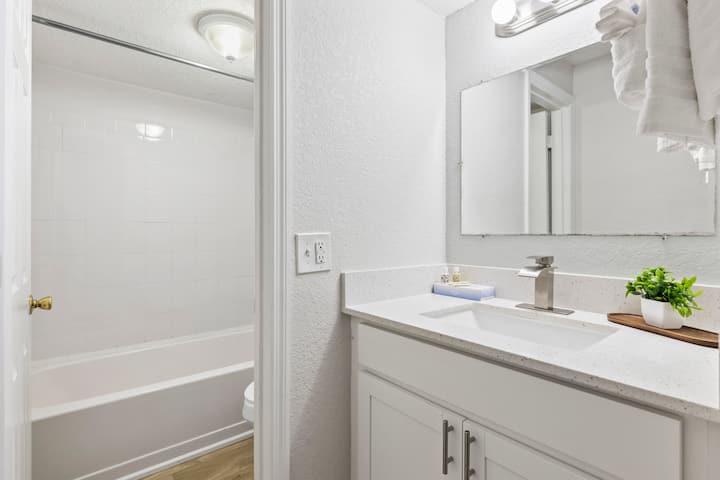 Bright white bathroom with sink and bathtub