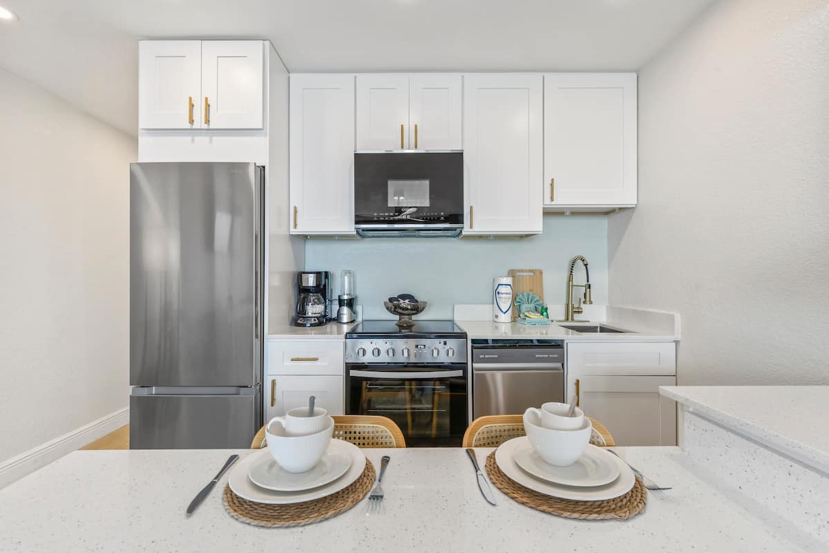 Modern kitchen with stainless appliances, two place settings