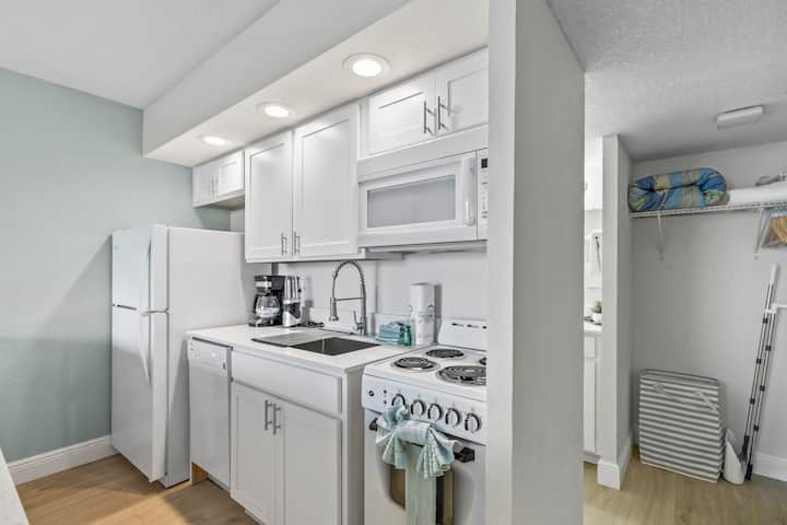 Compact white kitchenette with appliances and sink