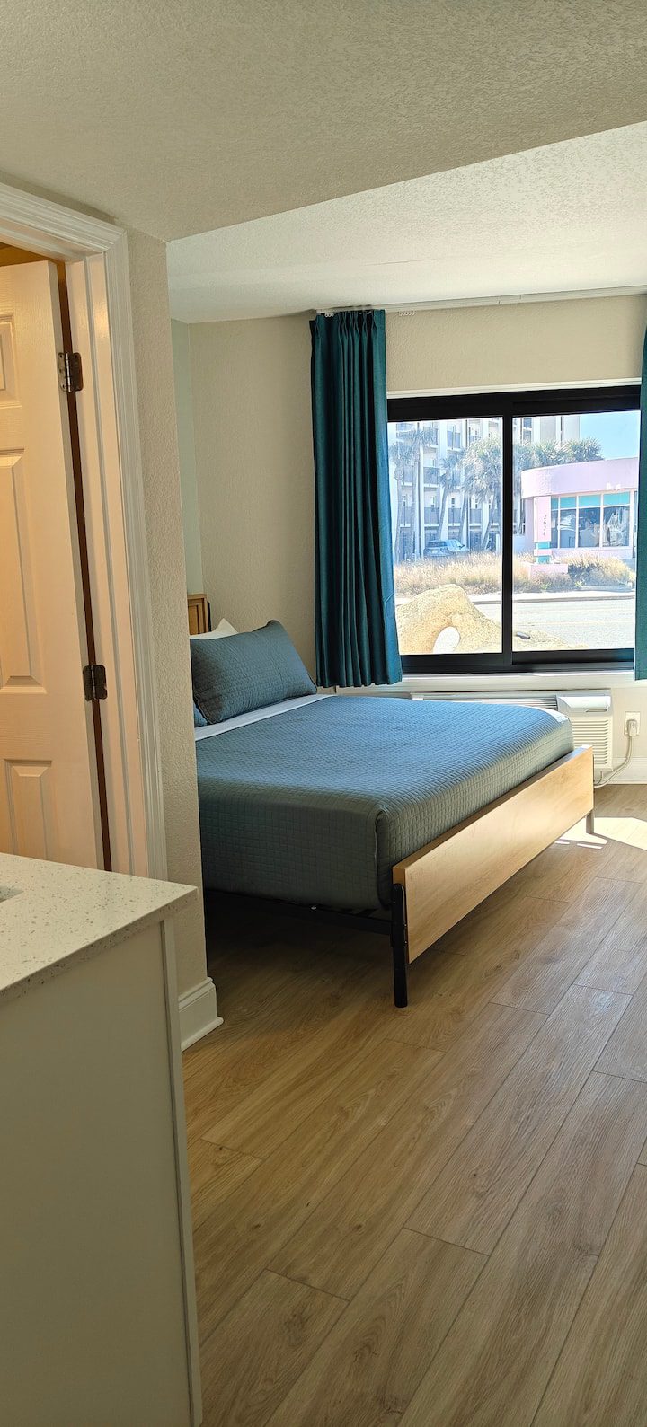 Modern bedroom with teal curtains and bed