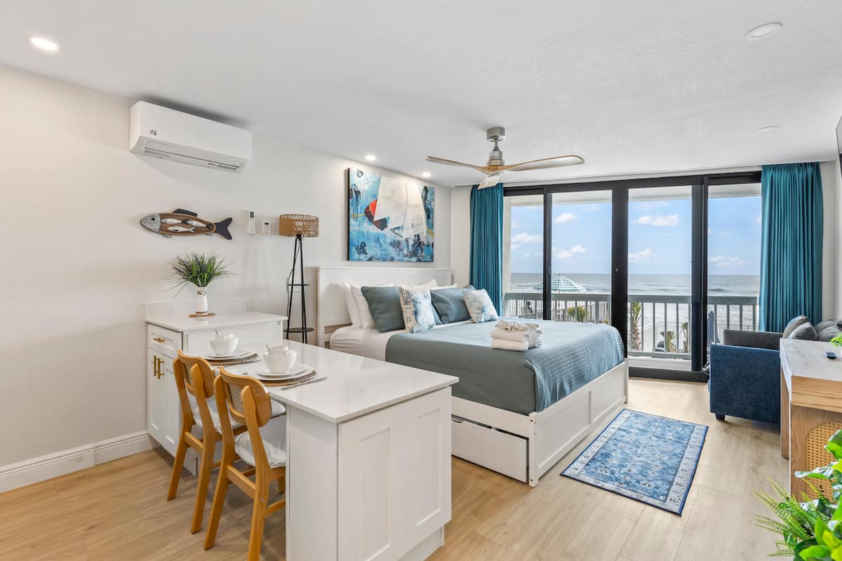 Coastal studio bedroom with ocean-view balcony